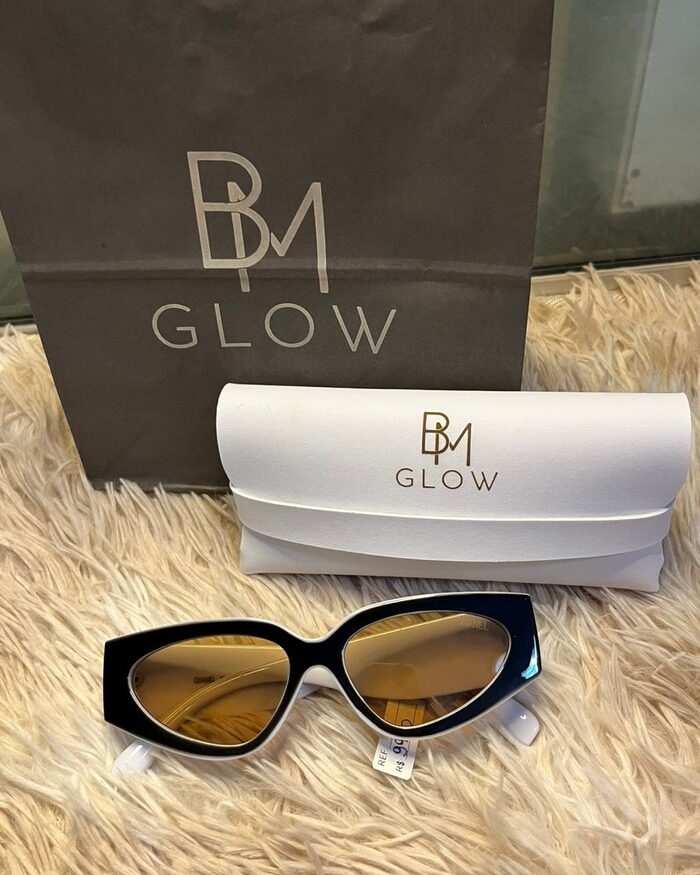 Sacola escura com a logo BM GLOW e estojo branco da marca