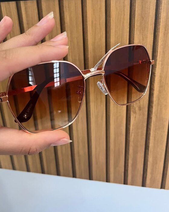 Óculos hexagonal com armação rosé e lente marrom degradê